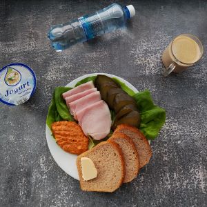 Dieta z ograniczeniem łatwoprzyswajalnych węglowodanów  masło extra 82% Schab Ojca Grzegorza Sałata zielona Kawa zbożowa z mlekiem Chleb Graham Jogurt naturalny Hummus paprykowy Woda mineralna Ogórek kiszony